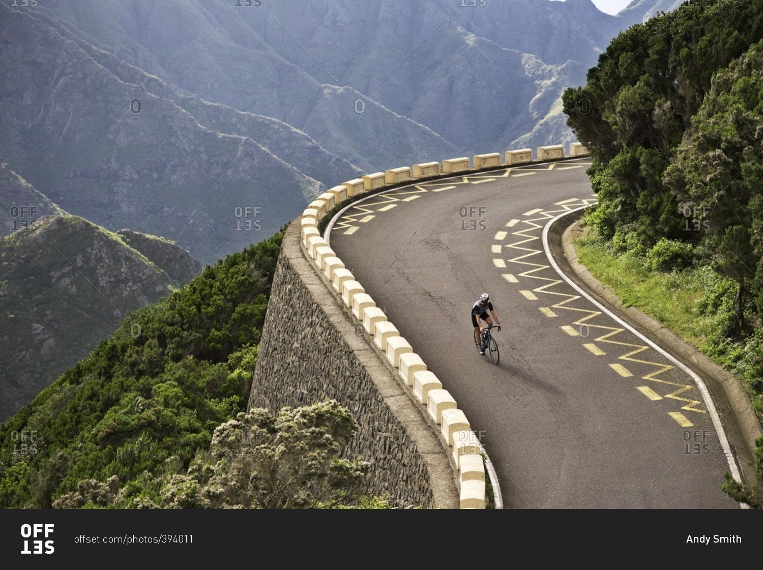Cyclist descending a steep hill stock photo - OFFSET