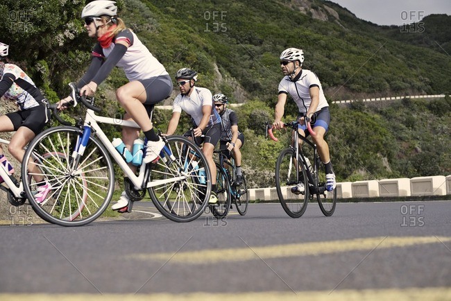 Group of cyclists ascending a steep hill together