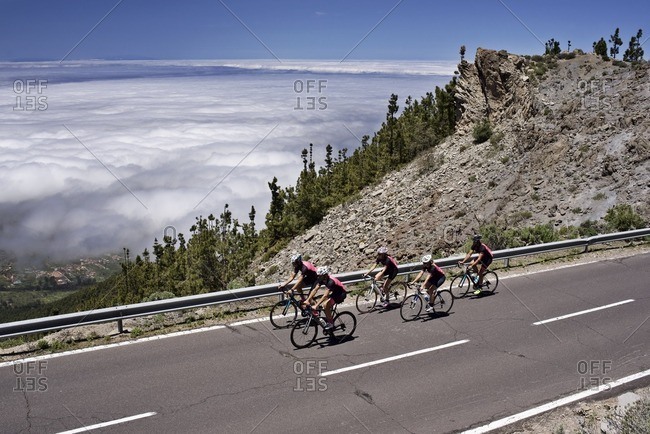 Group of cyclists riding along a scenic mountain road