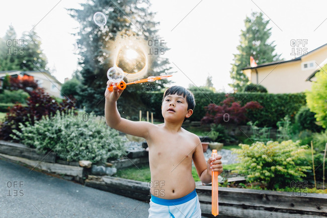 A boy making bubbles outside