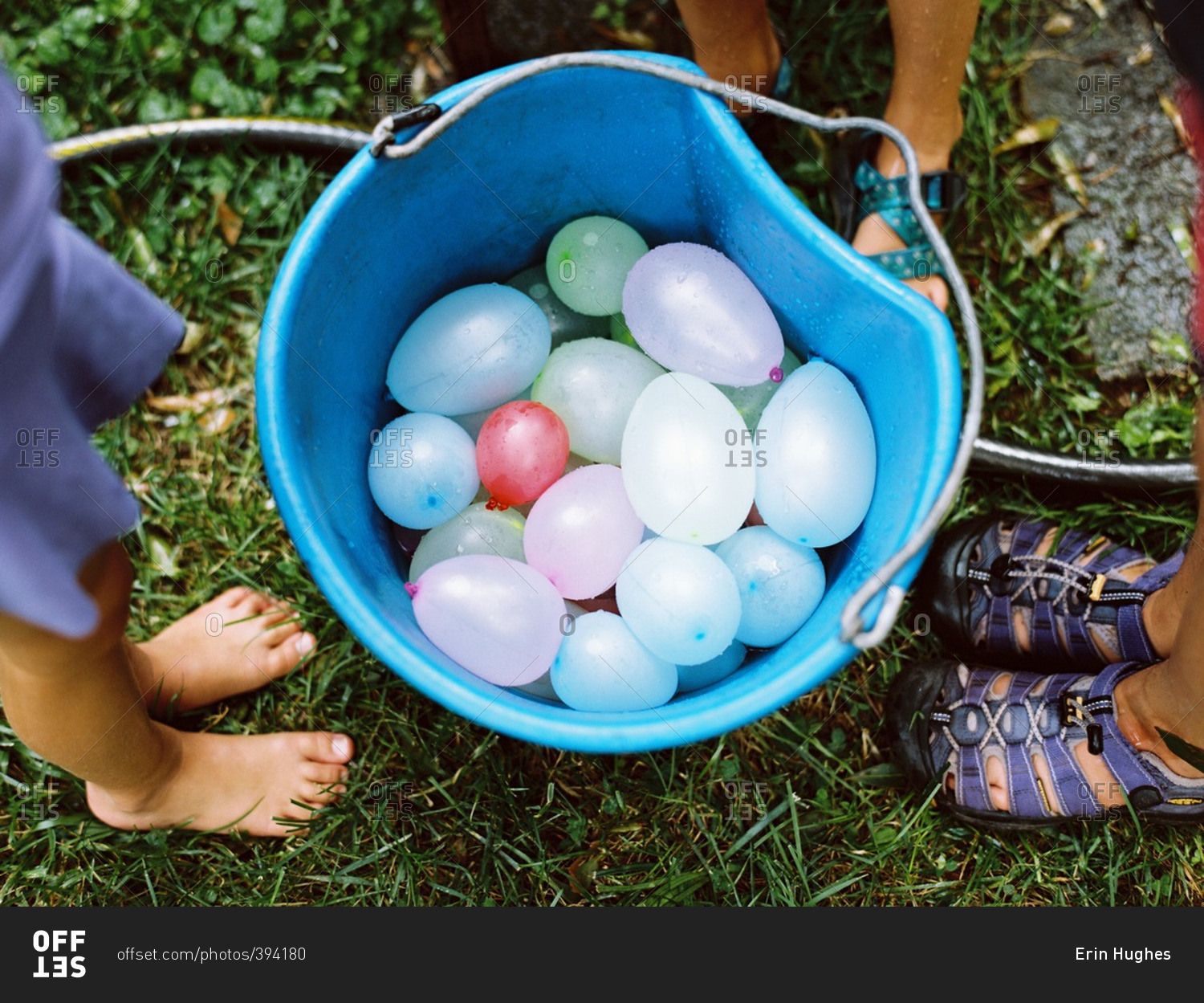 People around bucket with water balloons stock photo OFFSET