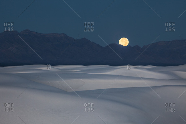 Full moon setting at dawn behind San Andres Mountains near White Sands National Monument