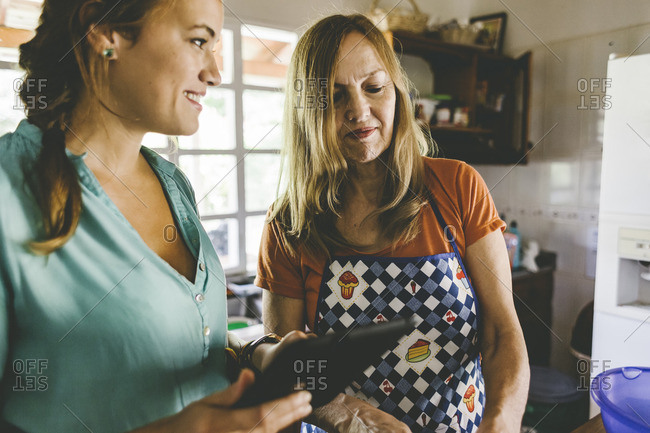 Women with tablet while cooking