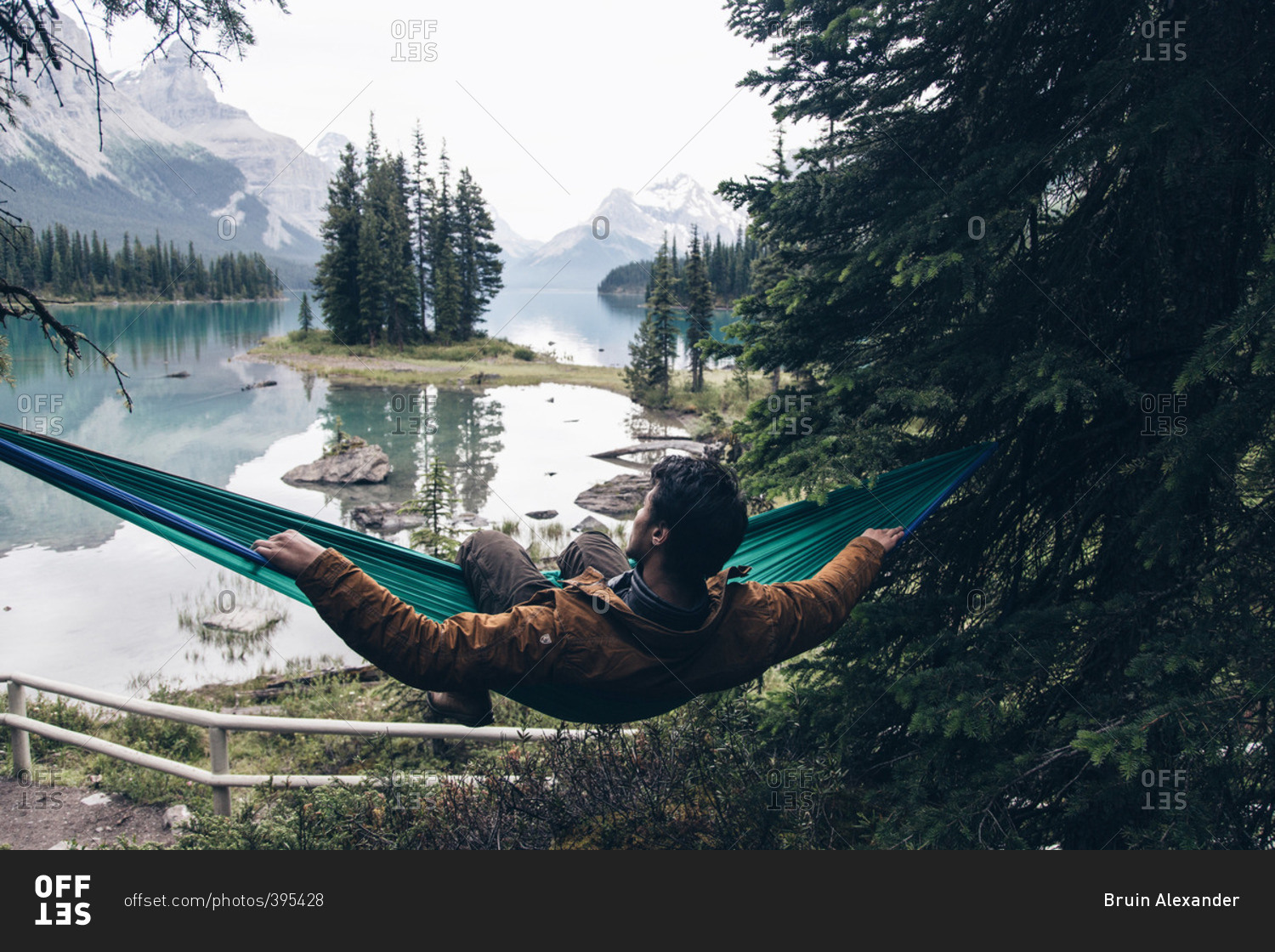 July 3, 2016 Man in hammock by mountain lake stock photo OFFSET