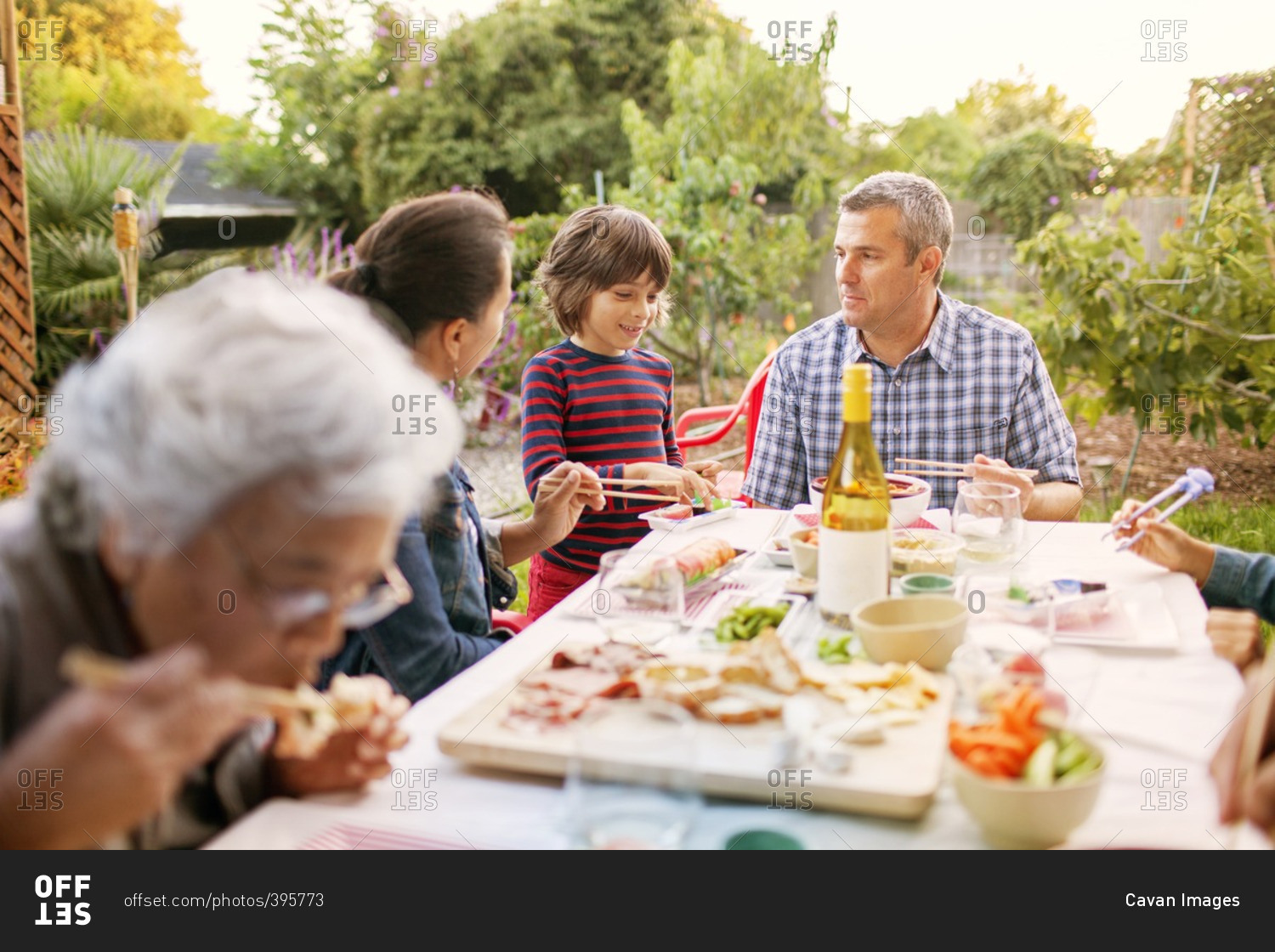 Family eating food on picnic table at backyard