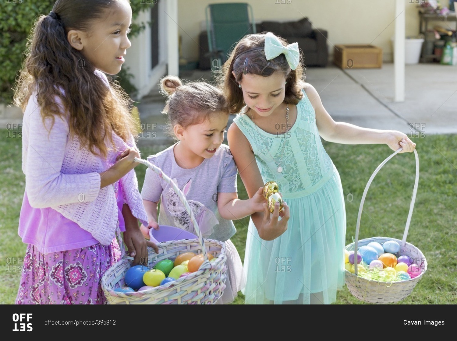 Happy sisters carrying Easter baskets at yard