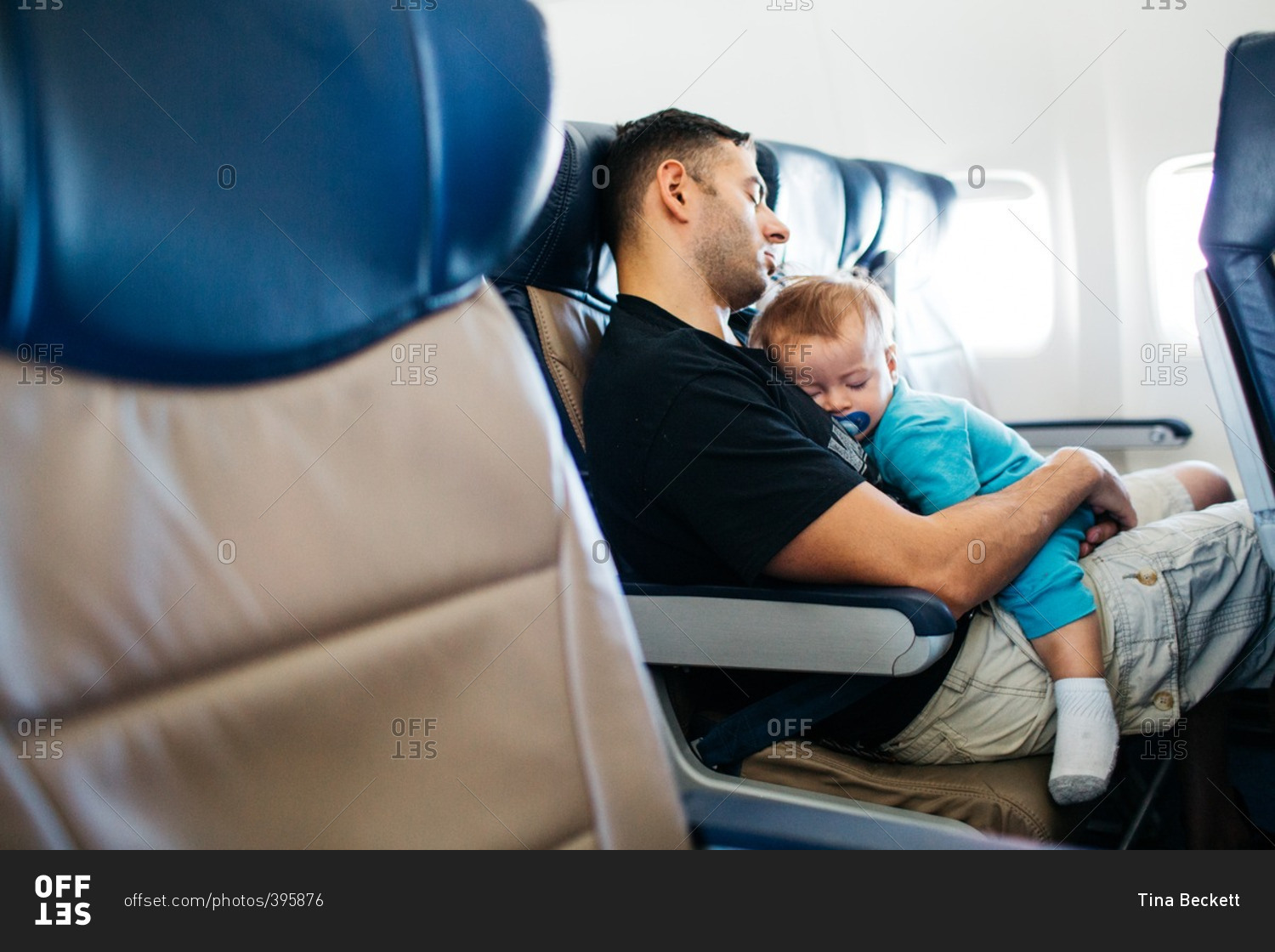 Dad and baby sleeping on plane