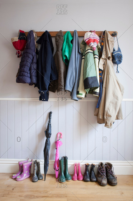 Coats on coat rack with boots