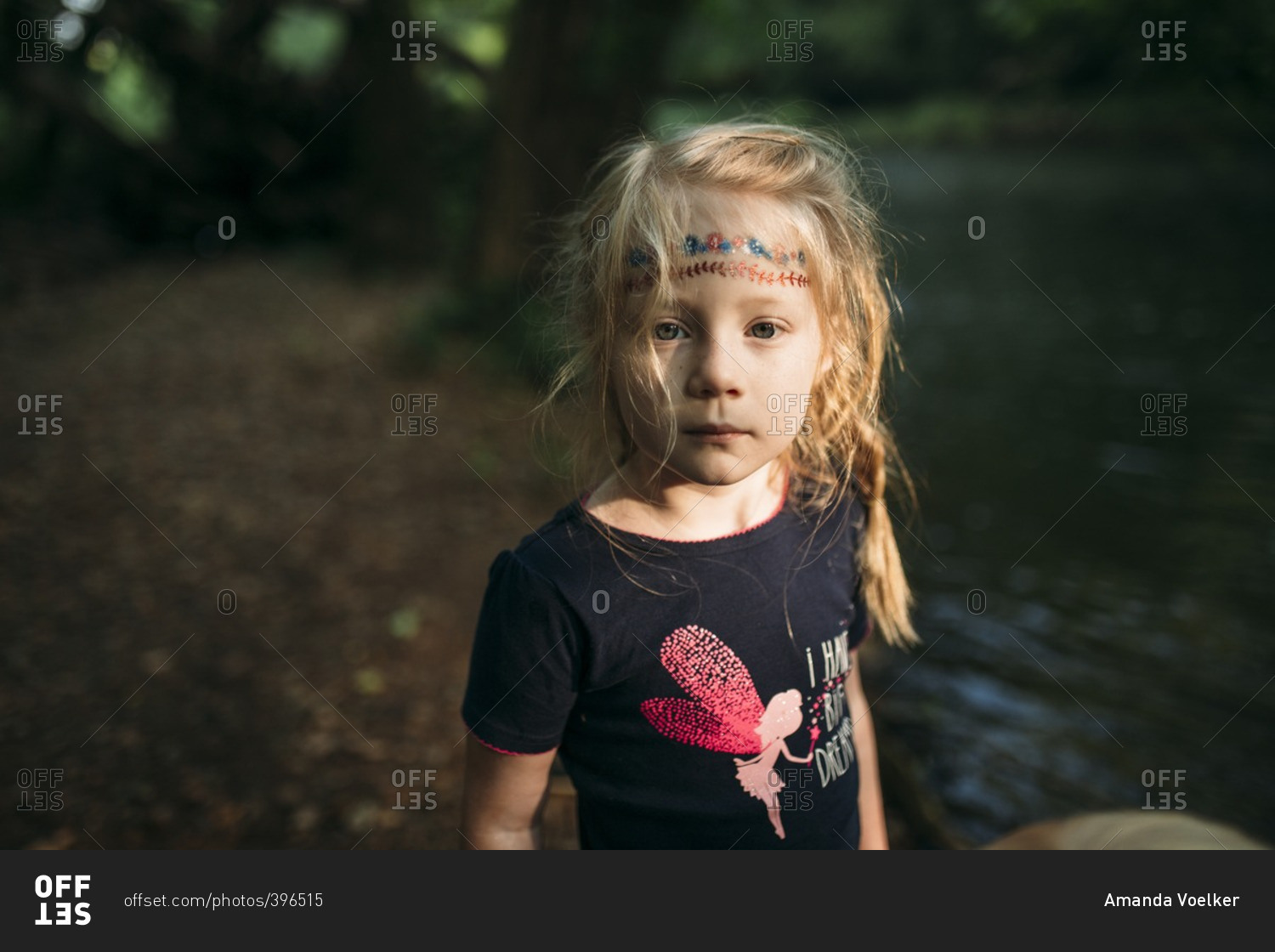 Portrait of a girl standing on the edge of a riverbank stock photo - OFFSET