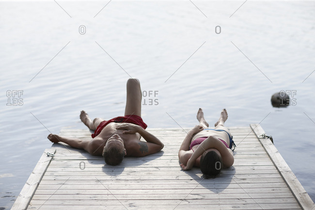 Sweden, Dalarna, Siljan, Man and woman lying on jetty