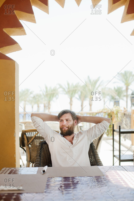 Egypt, Man sitting in chair with arms raised