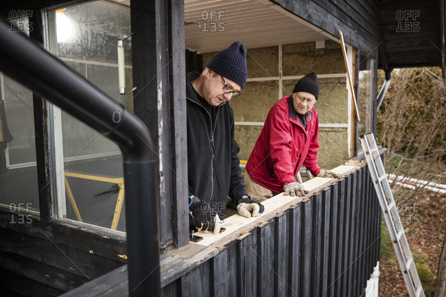 Sweden, Uppland, Rindo, Men building wooden balustrade