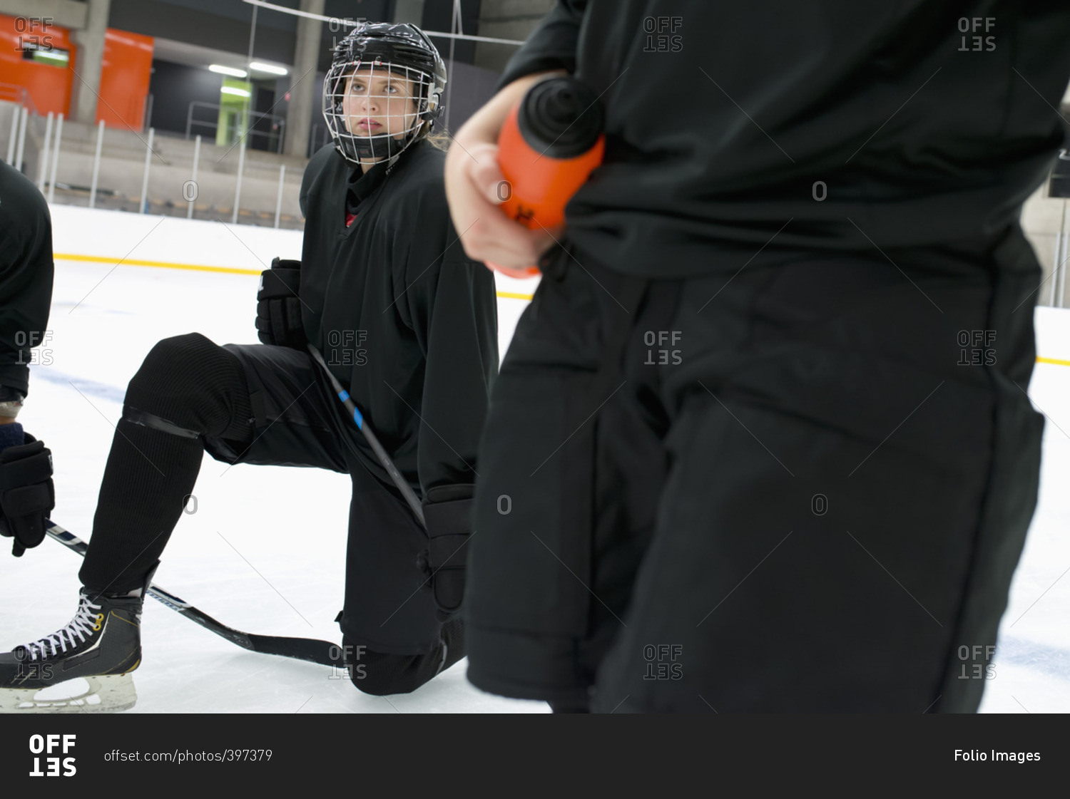 Sweden, Young hockey player wearing helmet kneeling on rink
