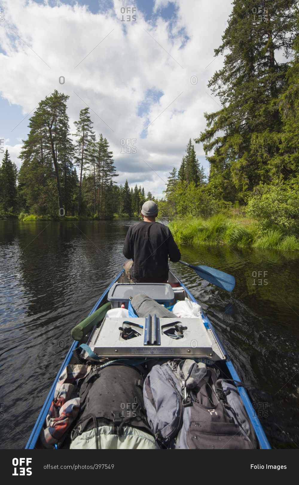 Sweden, Vastmanland, Svartalven, Man paddling canoe along river