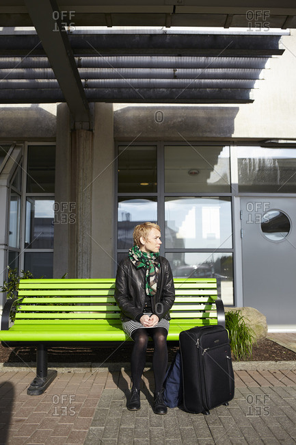 Sweden, Harryda, Landvetter, Woman sitting on bench at the airport