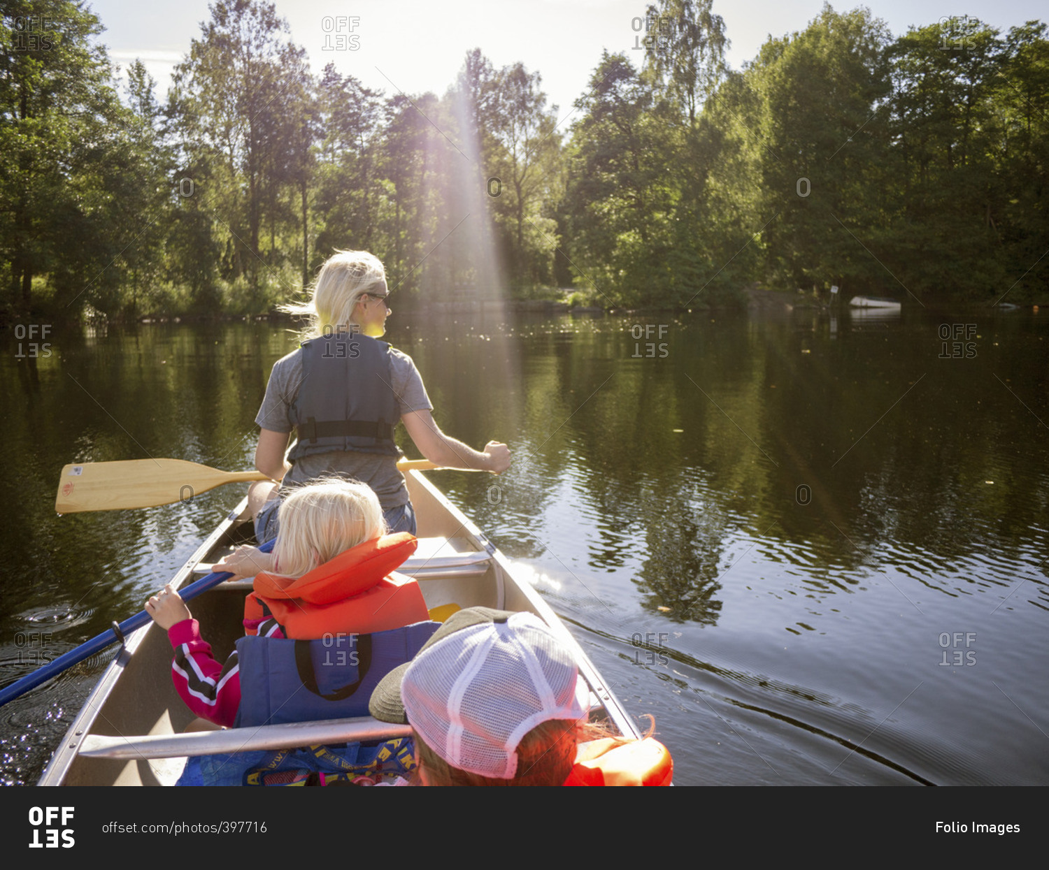 Sweden, Vastergotland, Lake Ommern, Mother, son and daughter navigating across lake in rowboat