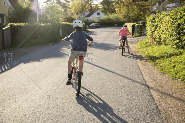 Sweden, Vastergotland, Lerum, Children (10-11, 12-13) cycling in sunny day
