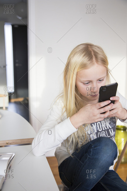 Sweden, Girl texting in living room