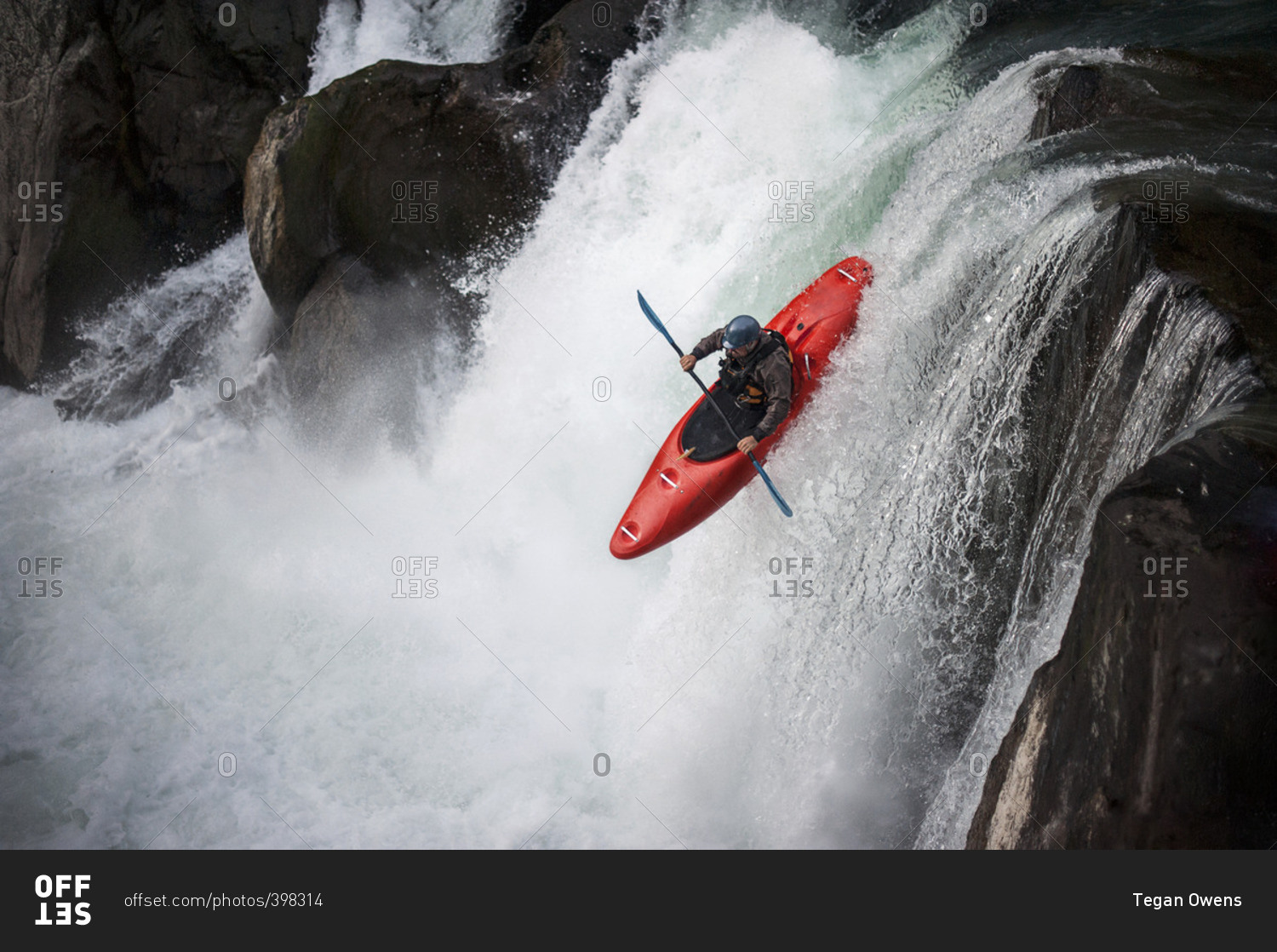 Man kayaking down a waterfall