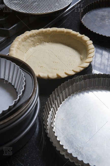 Pie Crust in Pan Near Other Empty Pie Pans