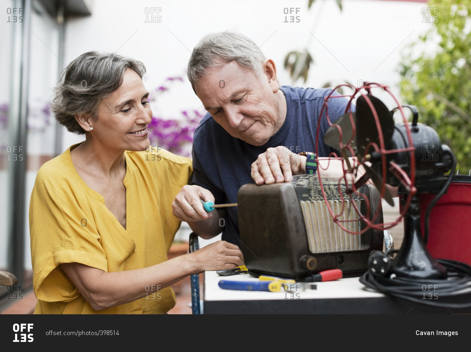 Senior couple repairing old-fashioned radio at yard