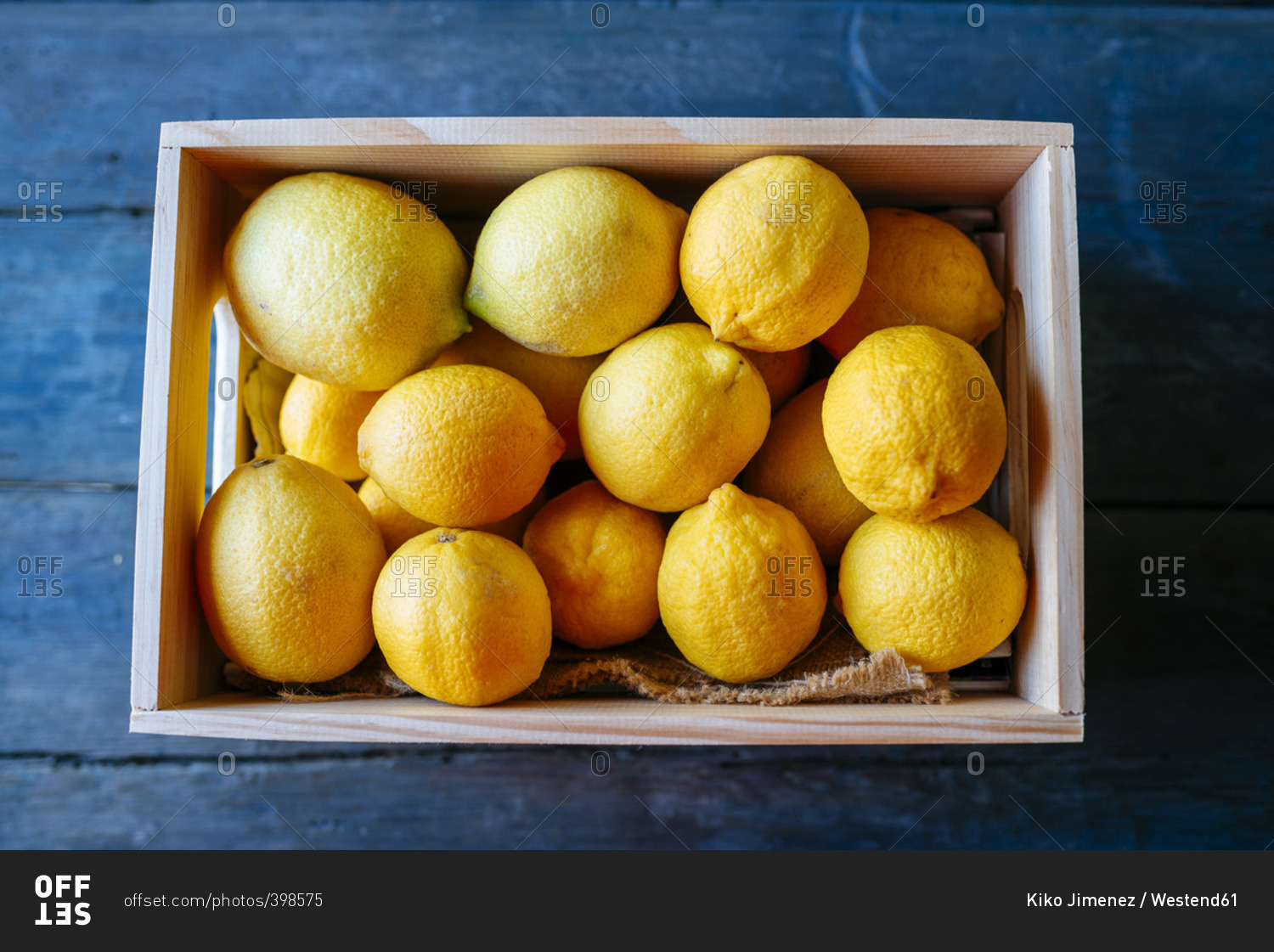 Lemons in wooden box on blue wood
