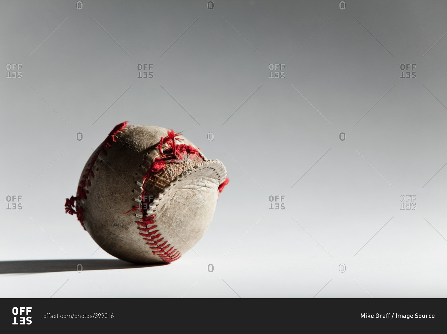 Worn baseball with broken stitching
