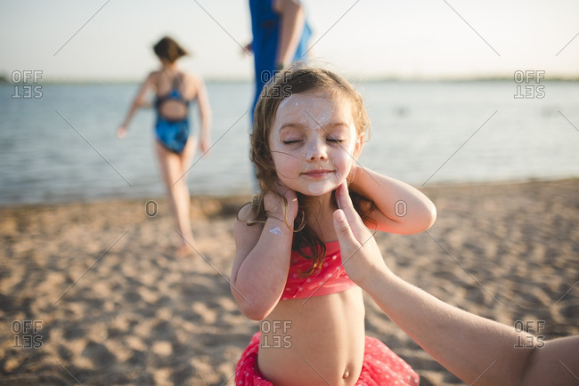 Girl applying sun screen at beach