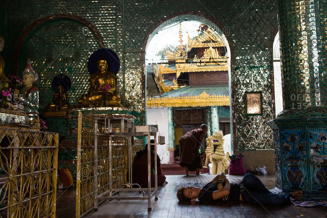Bago, Myanmar - January 3, 2015: A man sleeps the heat away at the Shwemawdaw Paya Pagoda