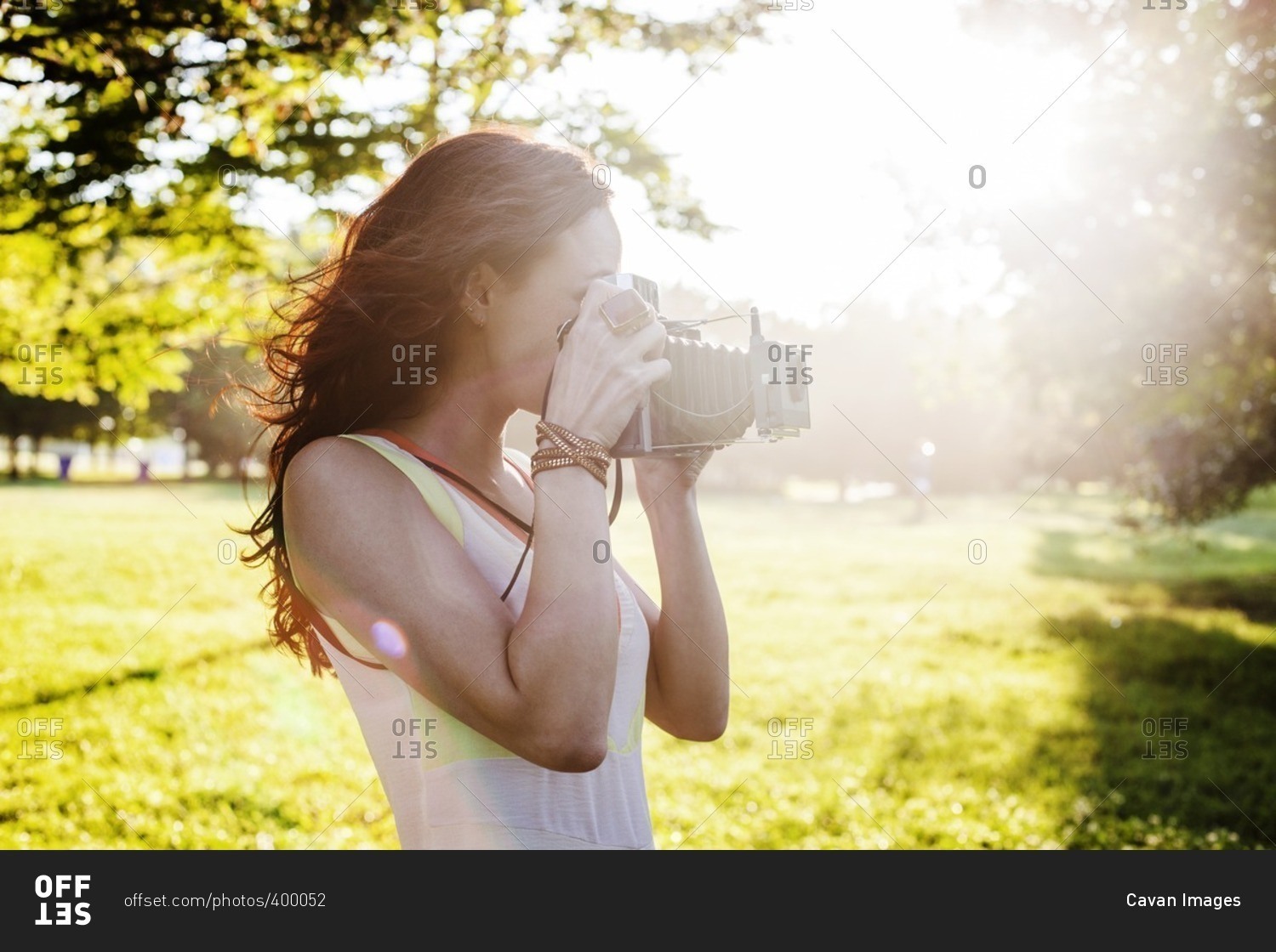 Side view of woman photographing through retro styled camera