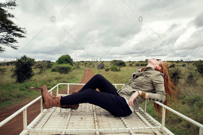 Woman enjoying ride on top of vehicle in wildlife park, Nairobi, Kenya