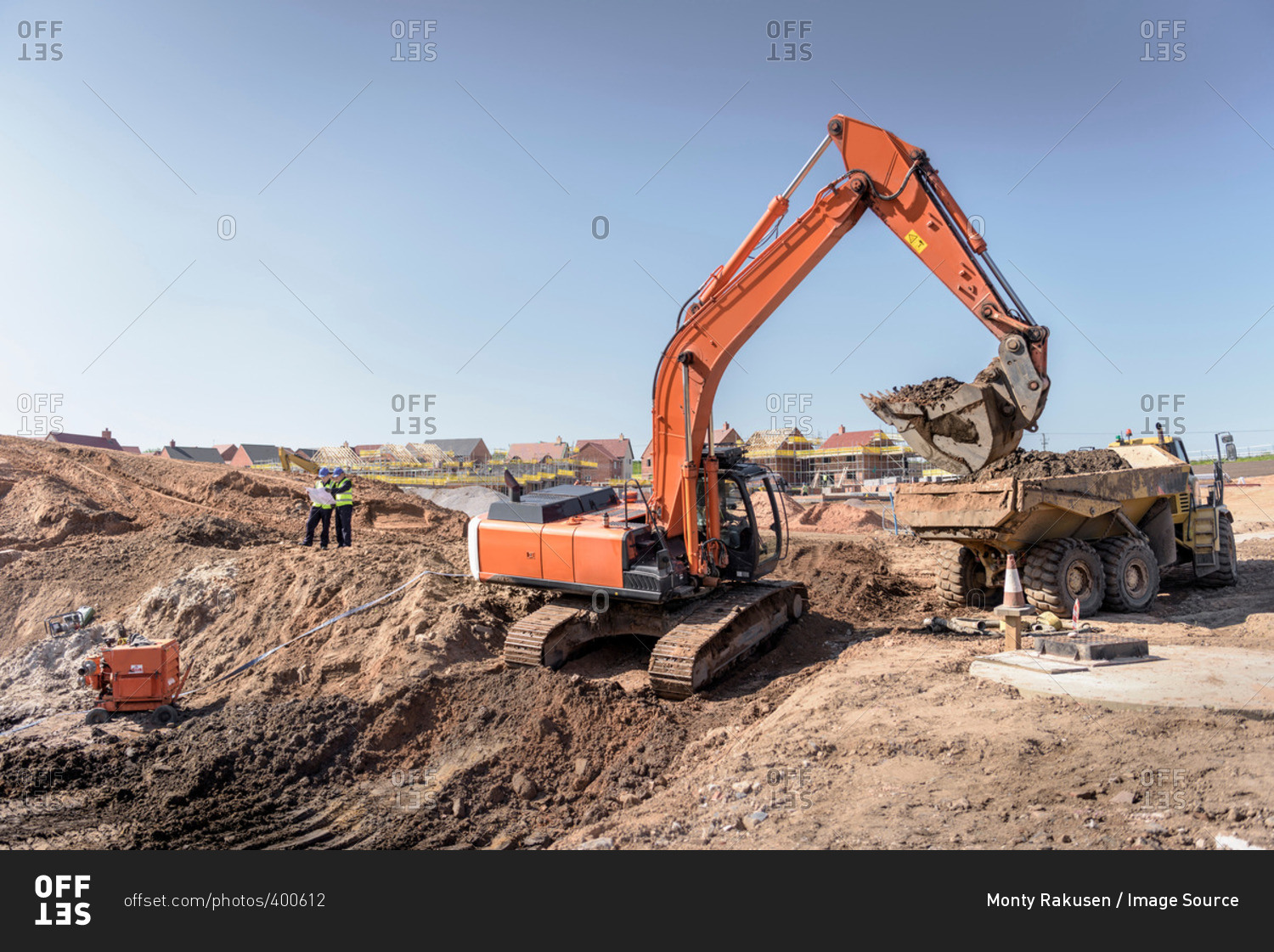 Excavator moving earth on housing site