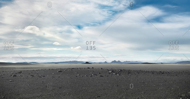 Grey barren landscape under cloudy sky