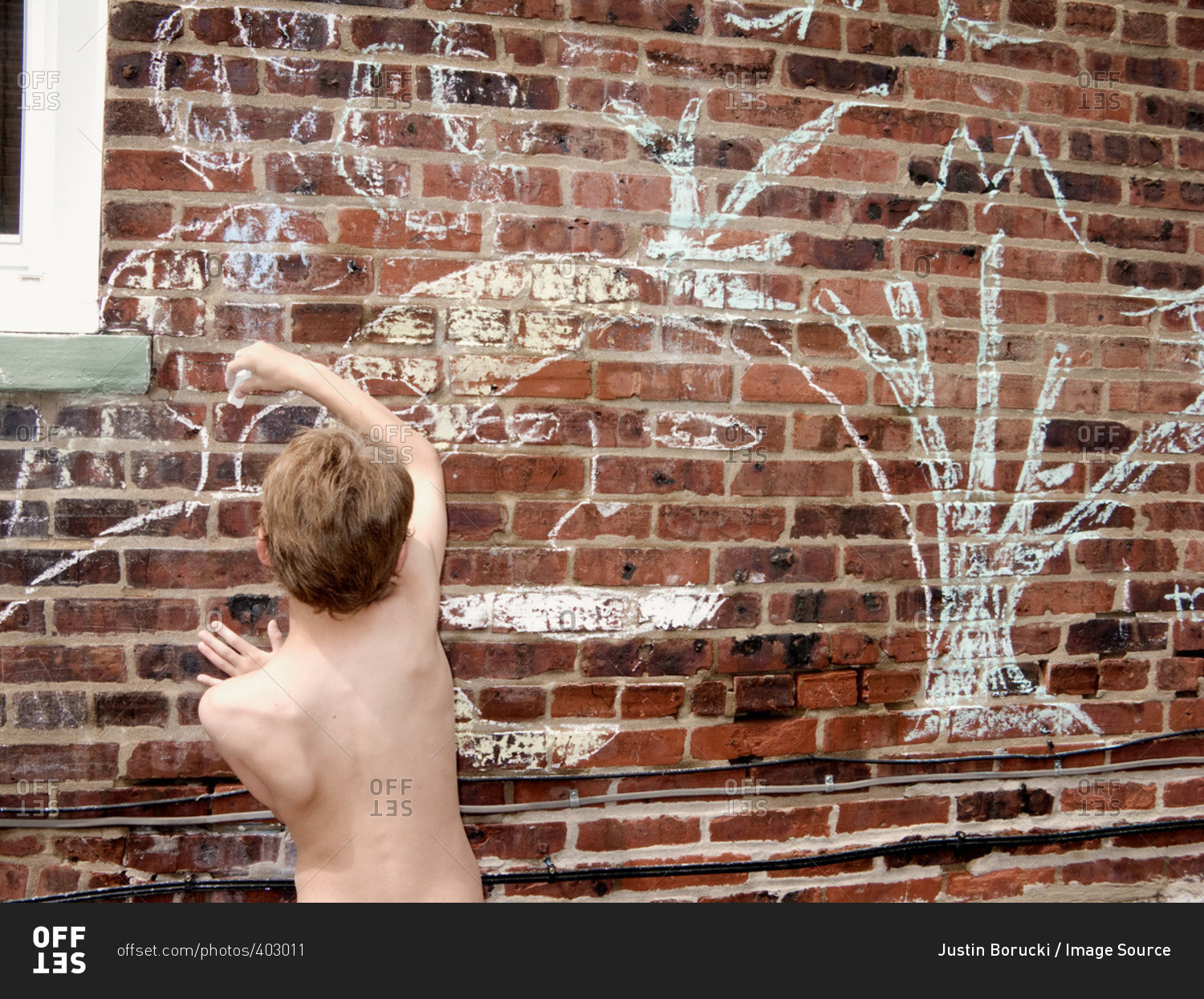 Boy chalk drawing on brick wall