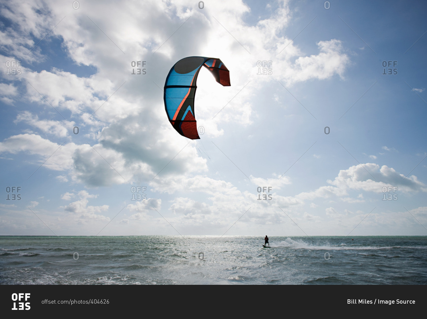Young man kite surfing on partially cloudy day
