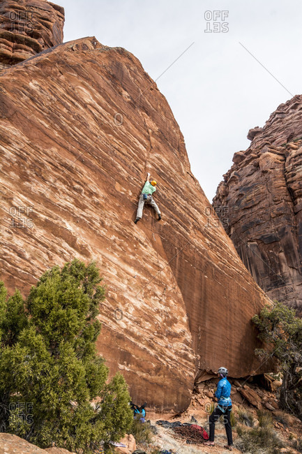 A man and woman rock climbing on the Hamm Boulder in Big Gypsum Valley, Naturita, Colorado