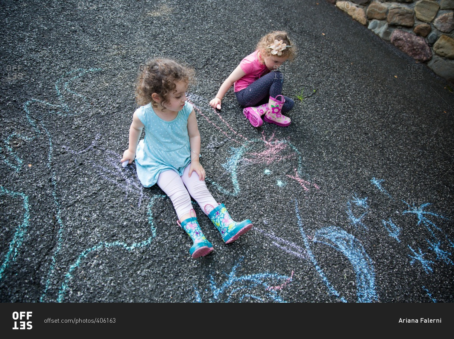 Girls drawing on pavement chalk