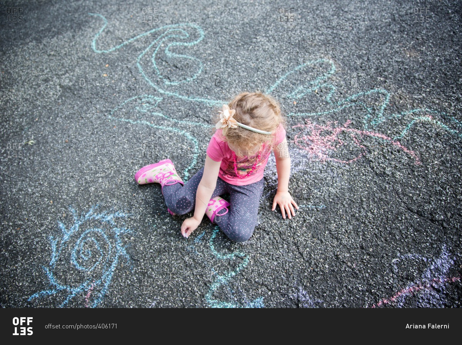 A girl drawing with chalk on pavement