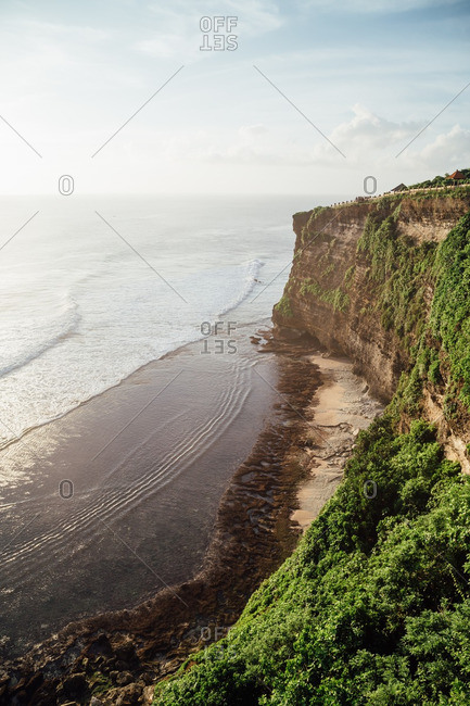 Sunlit ocean by a cliff