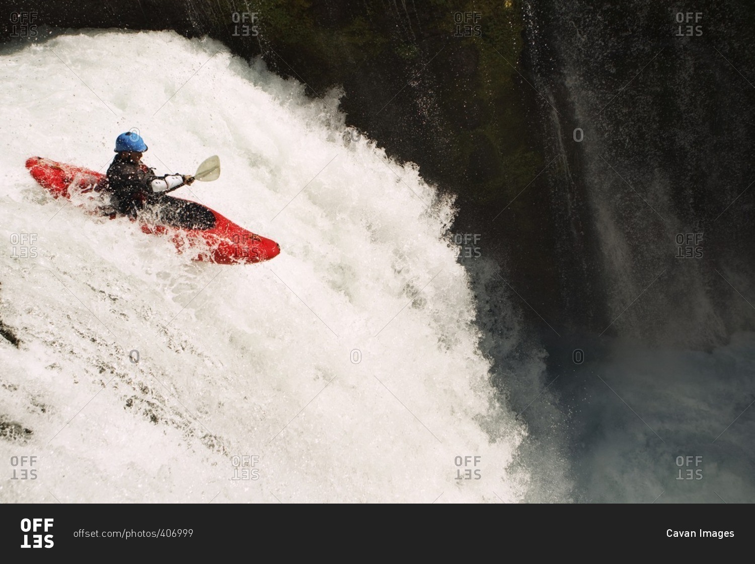 Man kayaking on waterfall on river