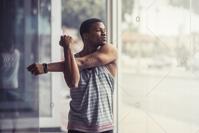 Athletic man stretching his arms before workout