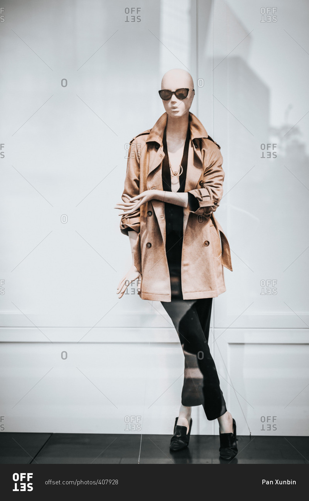 Mannequin in trench coat in shop window