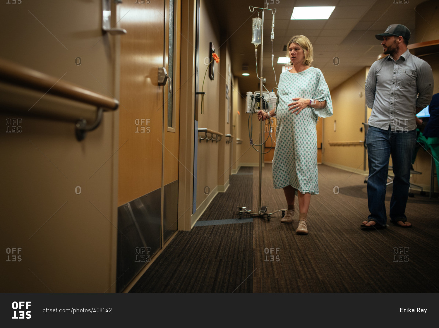 Pregnant woman walking with her husband in a hospital hallway during pre-labor