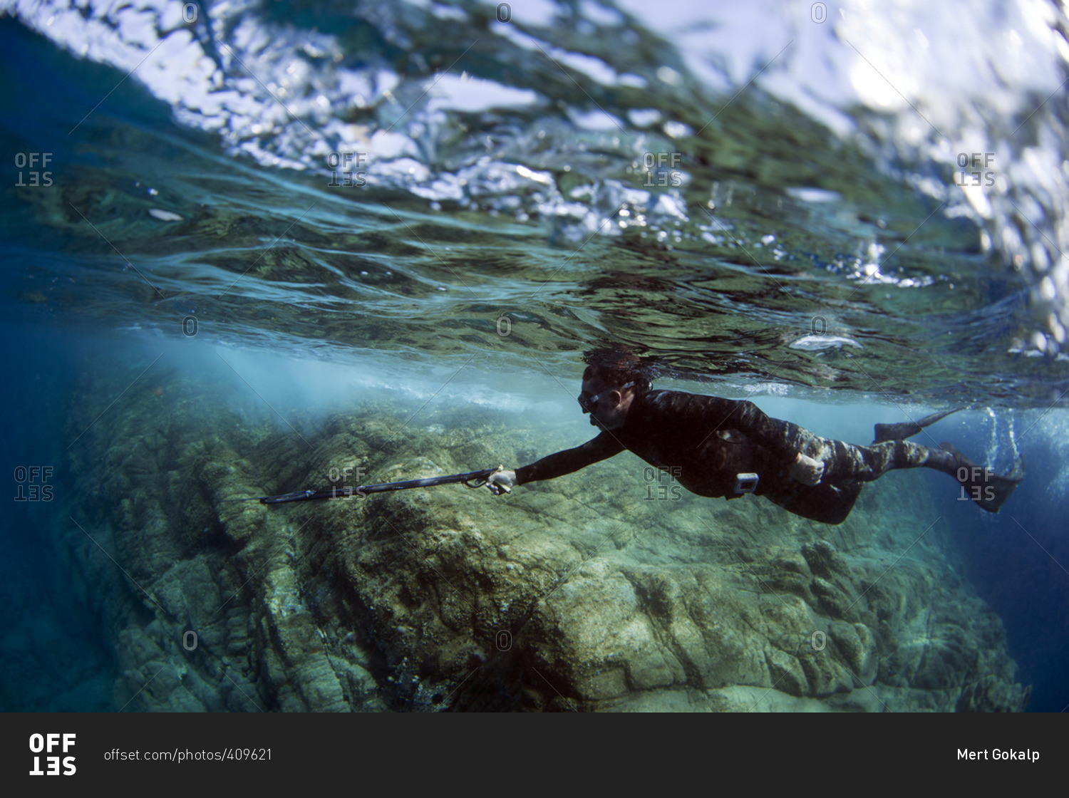 Underwater view of a diver spearfishing at coral reef stock photo OFFSET