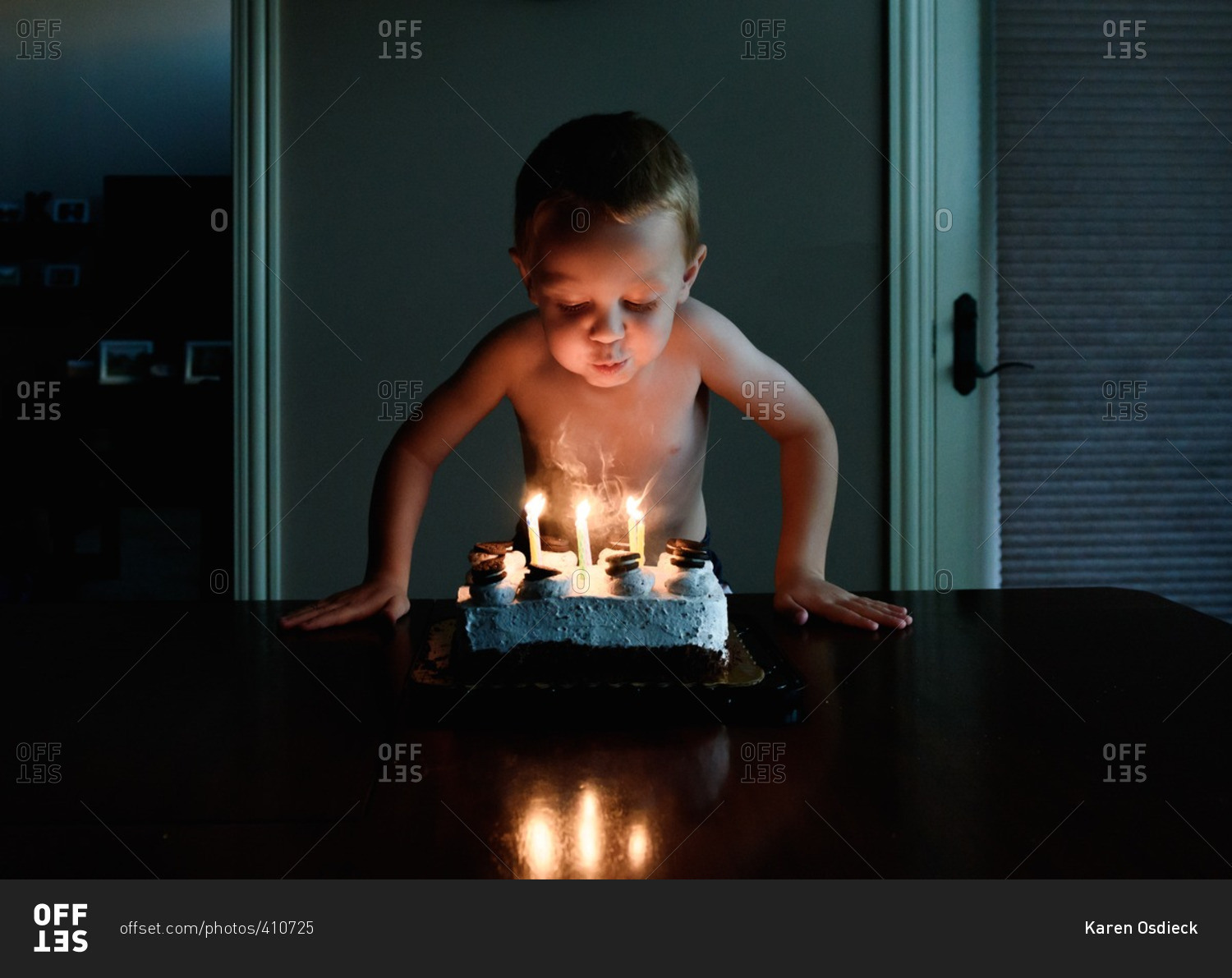 Young boy blowing out candles on his birthday cake