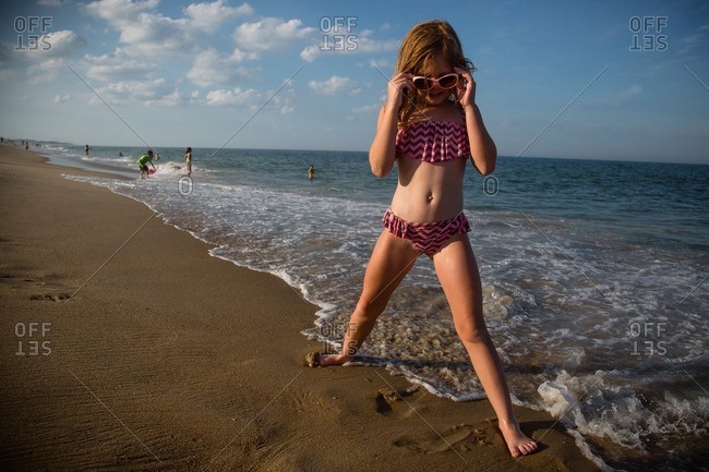 Little Girl Standing With Her Legs Outstretched On A Beach Stock Photo Offset