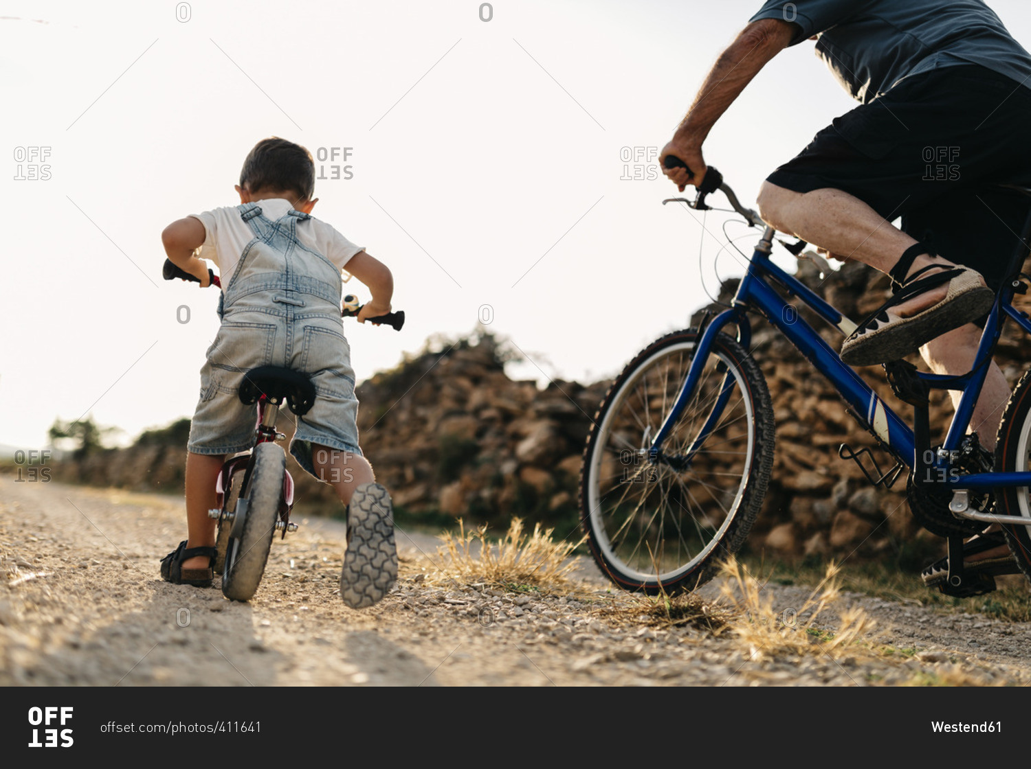 Back view of little boy and his great, grandfather on bicycle tour