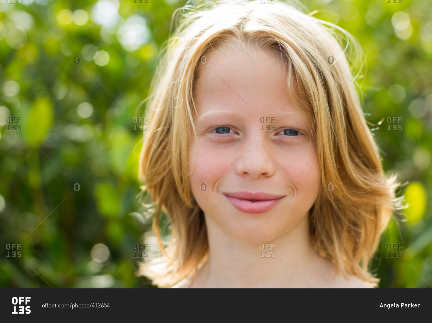 Headshot of boy with long hair stock photo - OFFSET