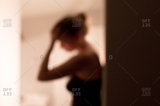 Blurry woman with hand on forehead