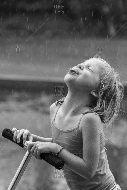 Girl catching raindrops on her tongue